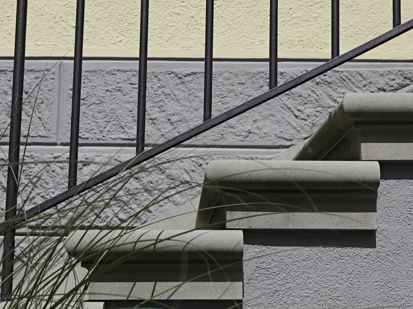 Detailopname van een trap en de kleurige overgang van de basis en het geveloppervlak.