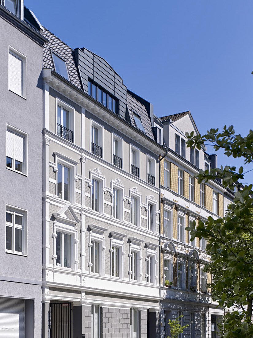 De gevelindeling neemt de verticaliteit van de Gründerzeit-architectuur over en herinterpreteert deze.
