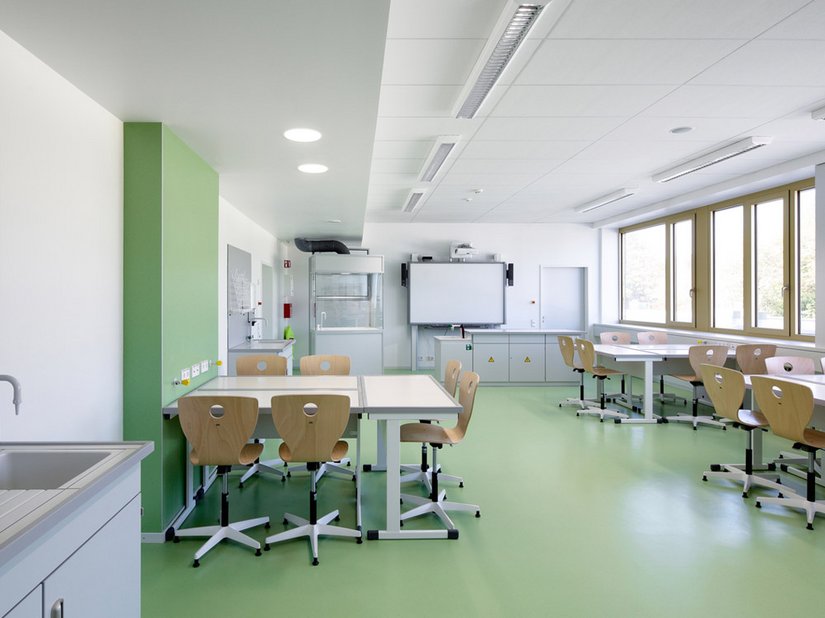 De kleuren lichtblauw, turquoise, groen en geelgroen zijn als kleurvlakken in de rubberen vloerbedekkingen ook terug te vinden in de lokalen en kantoorruimtes.