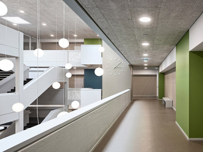 De twee vrijstaande trappen en de weringen van sierbeton zijn lichtgrijs gehouden en door de nieuwe leuningen met verhoogde borstweringen aangepast aan de nieuwe regels.