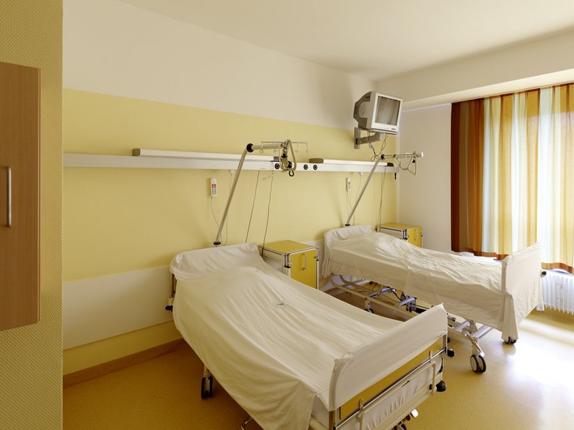 Zachte geeltinten brengen de zon tot in de kamer van de patiënt.
