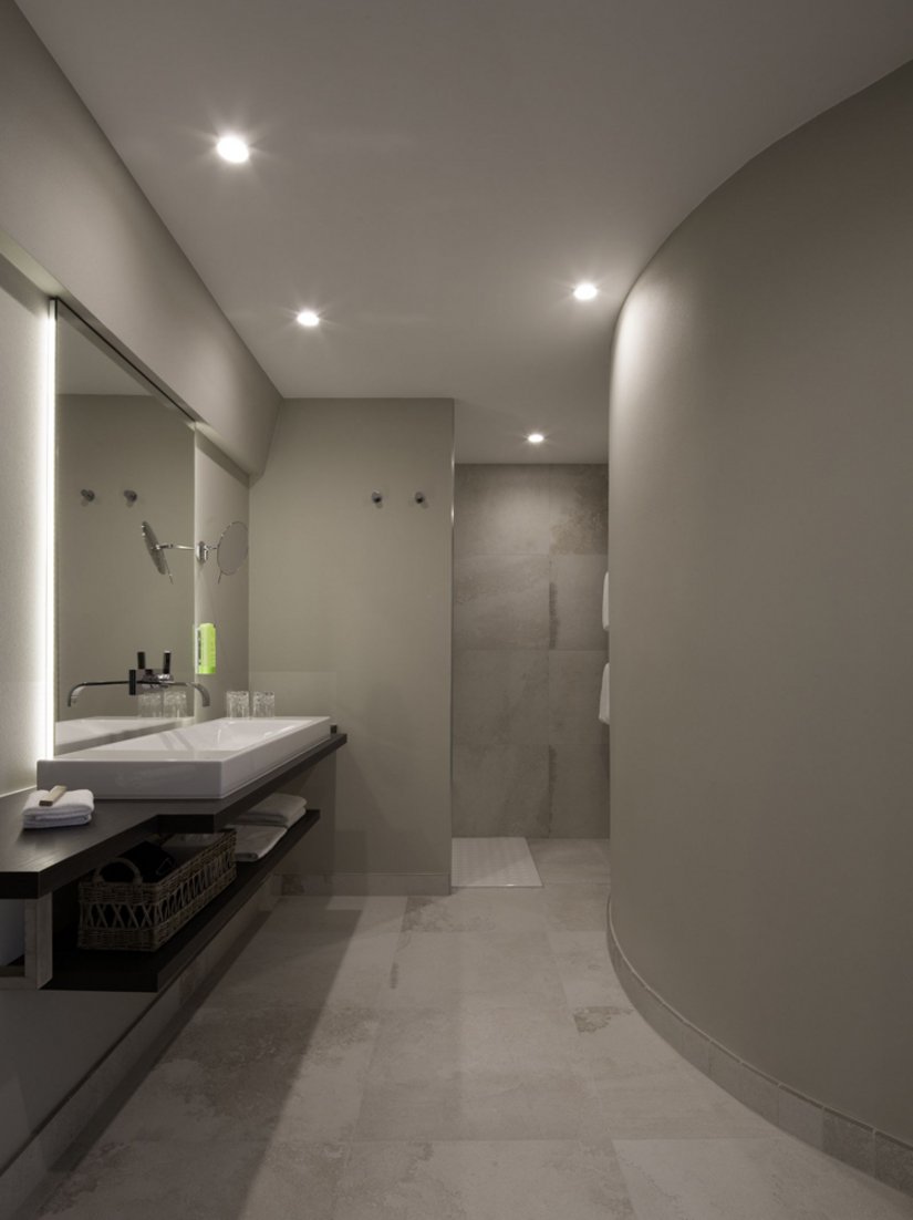 De badkamers zijn elegant en licht en bieden met een ruim bemeten inloopdouche met regendouche, kamerhoge spiegel en handdoekradiator ook alle comfort.