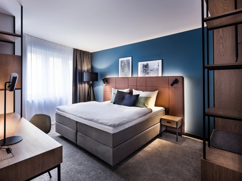 Blauw als het water en mosgroen als terugkerende kleuren op de muren, in het meubilair en in het textiel verwijzen naar de rivier de Neckar, aan wiens oevers het hotel ligt.
Foto © DIA – DITTEL ARCHITEKTEN