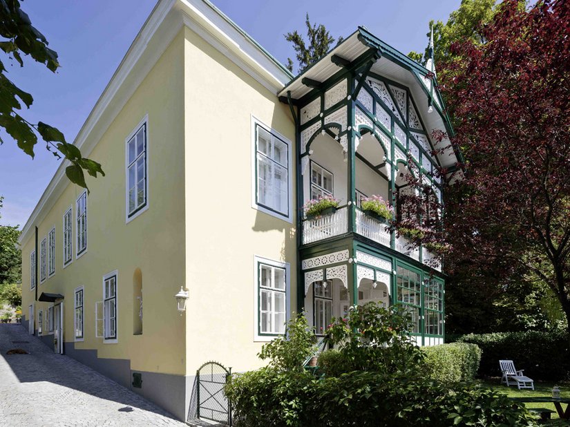 De opvallende houten veranda van de villa, met houtsnijwerk in biedermeierstijl, is in zijn geheel opgeknapt.