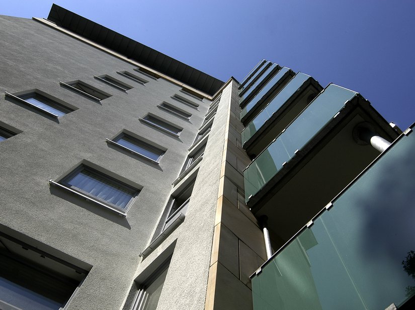 Een keur aan op elkaar afgestemde kleuren en gevelmaterialen in verschillende optische en haptische kwaliteiten zorgt ervoor dat deze monoliet een veel minder kolossale indruk maakt. Interessant: de voorgehangen zandsteenelementen die hier zijn gecombineerd met een WDV-system.