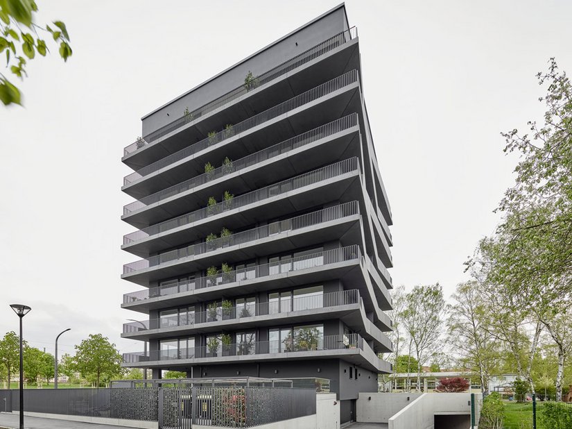 De interactie van de schommelende en dansende balkonbalustrades met de monolitisch oprijzende gebouwstructuur geeft het een bijna gewichtloze en lichte uitstraling.