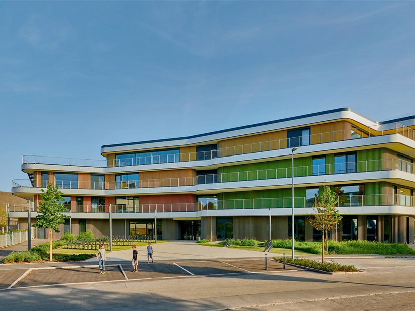 De nieuw gebouwde lagere en gemeenschapsschool, gevormd uit één organisch bouwwerk, slaagt erin het heterogene bestand van verschillende schoolgebouwen op de campus te herschikken.
Foto © David Matthiessen Fotografie