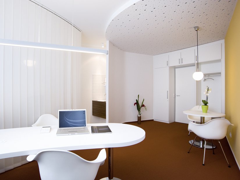 De in lichtoranje geschilderde wand creëert een vriendelijke, huiselijke sfeer.