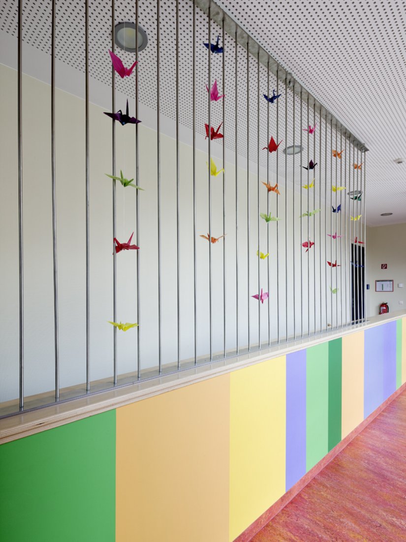 Het kleurenpalet van de uitspringende ramen wordt binnen in het gebouw herhaald.