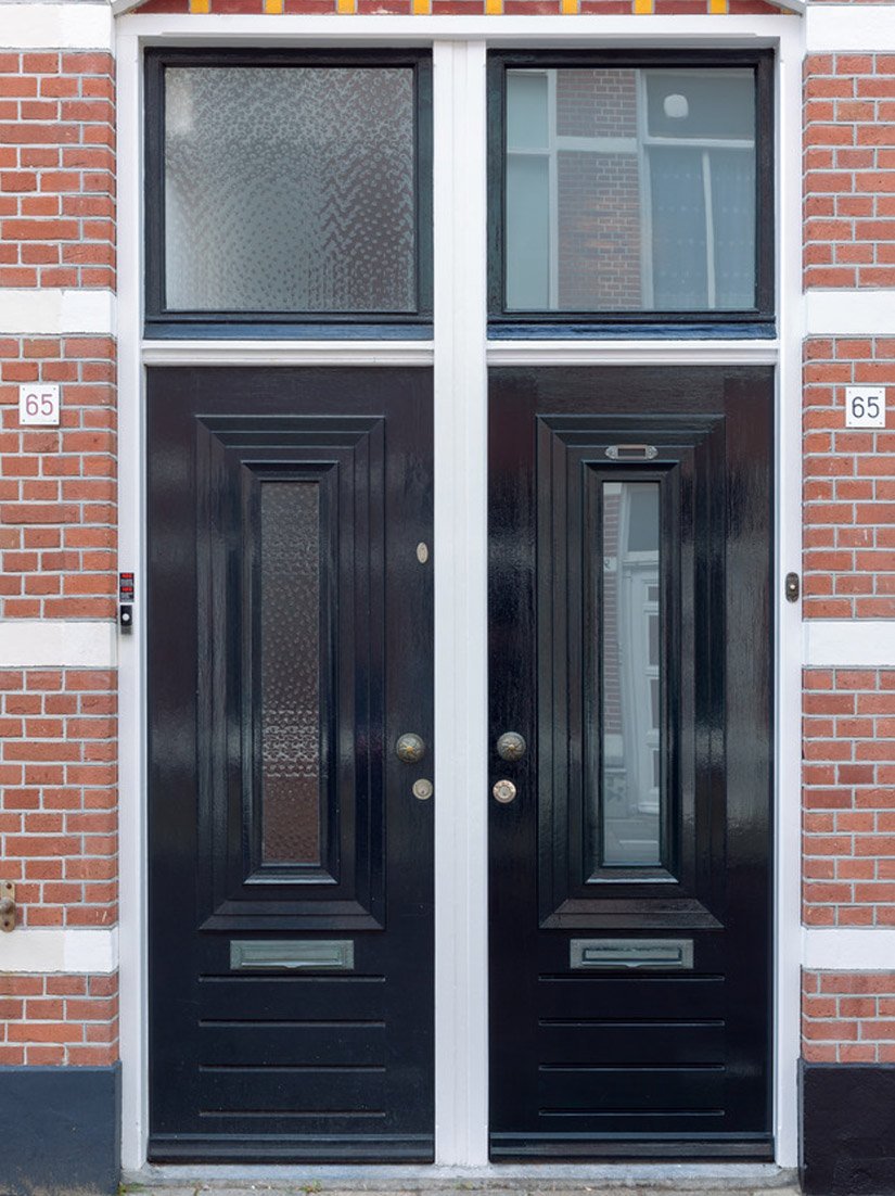 Glanzend, zwart gelakte deur- en raamelementen doorbreken het gevelbeeld.