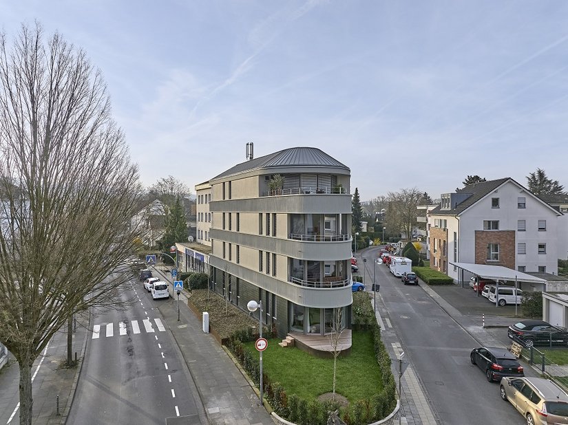 Succesvol project voor een meergezinswoning: een bestaand gebouw, een uitbouw – en uiteindelijk een overtuigende nieuwe constructie, die perfect in de groter geworden omgeving past. De gebogen top van het gebouw geeft het hoekgebouw een nieuwe stedenbouwkundige aanwezigheid.