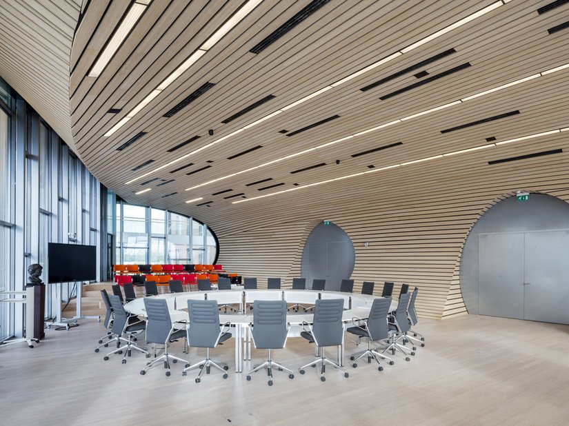 Ronde vormen en gebogen lijnen in combinatie met natuurlijke materialen zoals hout en veel glas, kenmerken het interieurontwerp.