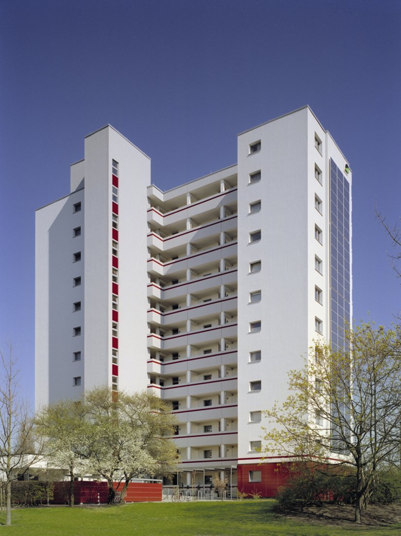 De rode kleur van de keramische bekleding is ook terug te vinden als horizontale structurering van de loggia’s en in de verticale vlakken onder de ramen.