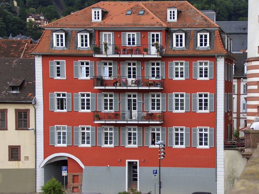 Rood en grijs domineren de gevel van dit oude schoolgebouw.