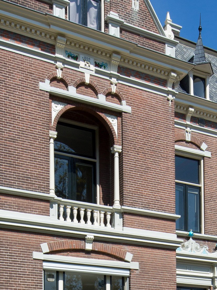 De bepleisterde delen van de monumentale gevel en de pleisterornamenten werden overschilderd met Siliconen-Gevelverf 918 en Top-Elastiek Gevelverf 380.